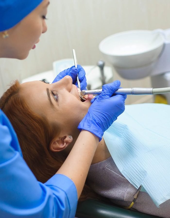 doctor-uniform-checking-up-female-patient-s-teeth-dental-clinic-min